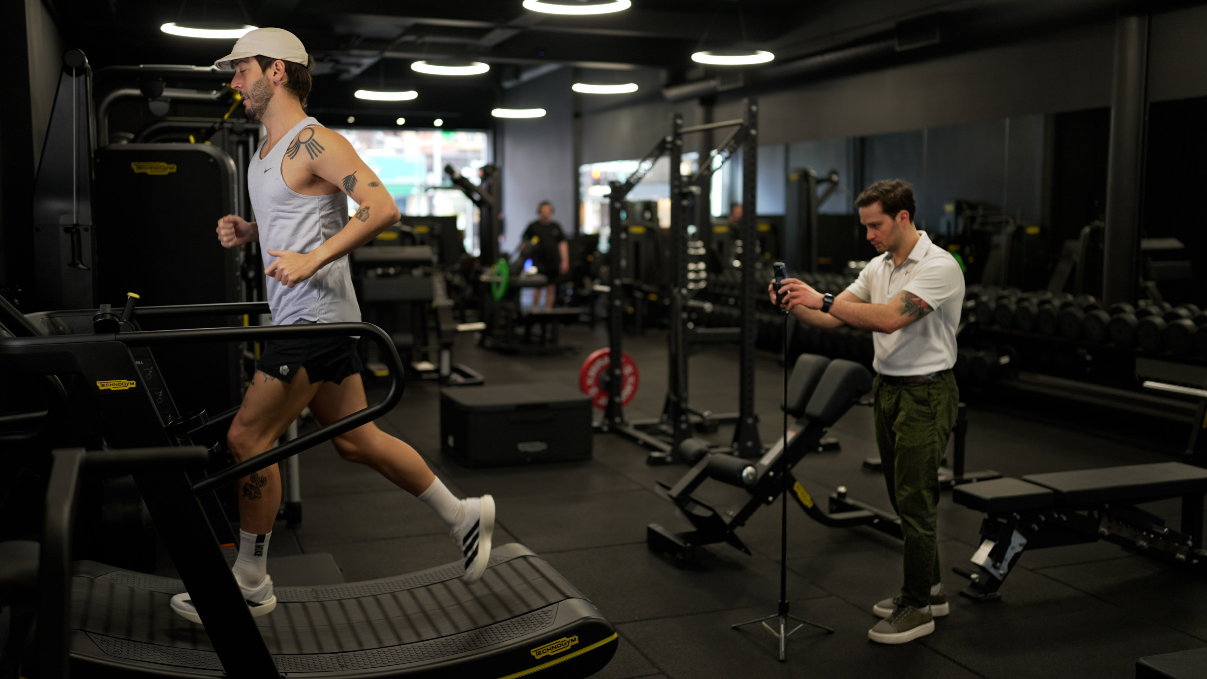 Alex Barmpas analysing a client's running gait on a treadmill